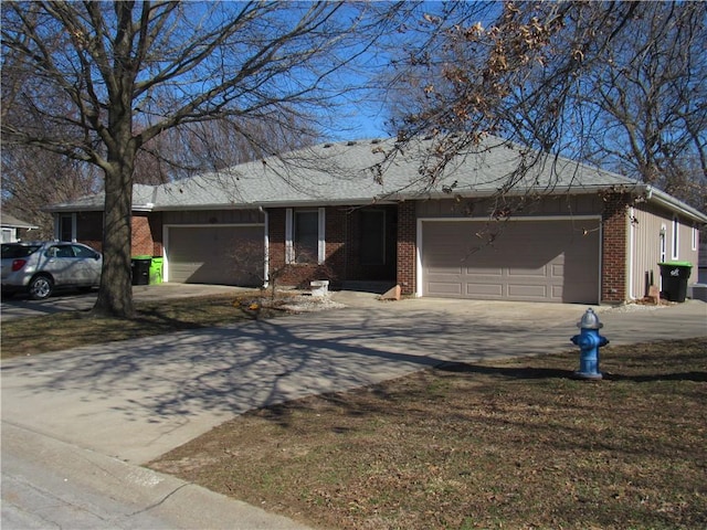 single story home with concrete driveway, an attached garage, and brick siding