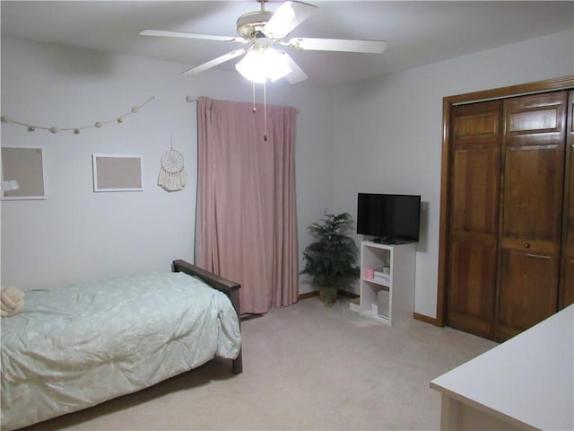 bedroom with baseboards, light carpet, a closet, and ceiling fan