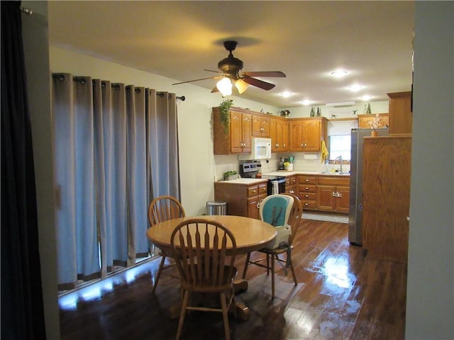 dining area with ceiling fan and dark wood-style flooring