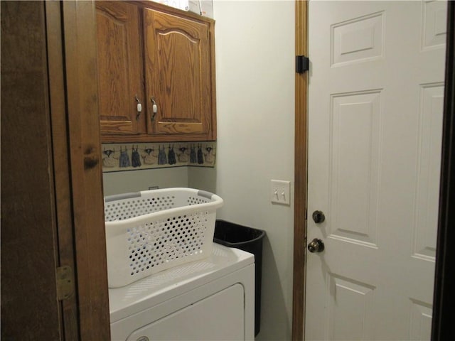 washroom with cabinet space and washer / dryer