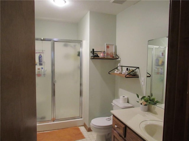 bathroom featuring tile patterned floors, a stall shower, toilet, and vanity