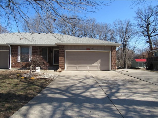 ranch-style home with concrete driveway, an attached garage, brick siding, and roof with shingles