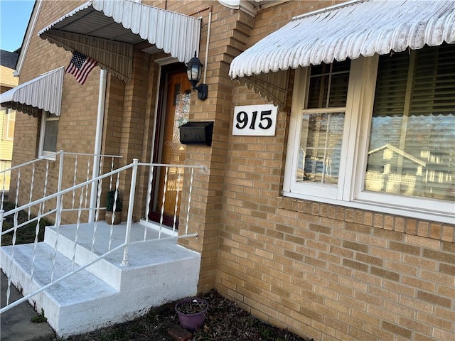 doorway to property with brick siding