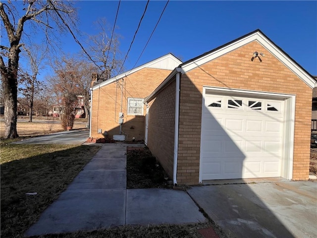 view of home's exterior with a garage, brick siding, and concrete driveway