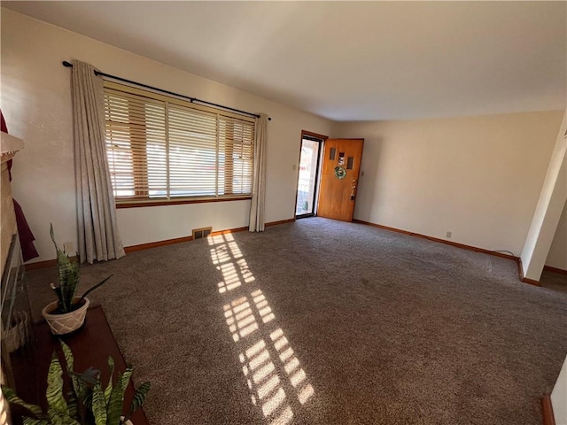 unfurnished living room featuring a fireplace, visible vents, carpet floors, and baseboards