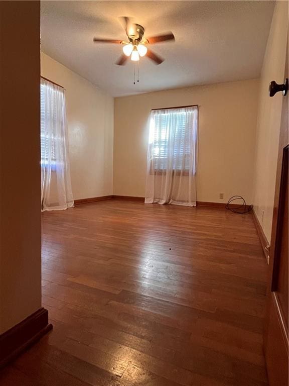 spare room with wood finished floors, baseboards, and ceiling fan