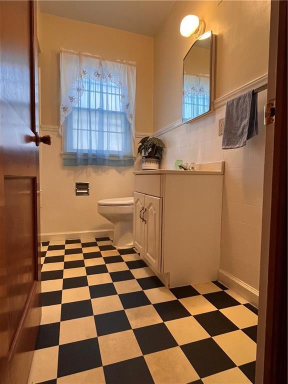 bathroom featuring vanity, tile patterned floors, toilet, and tile walls