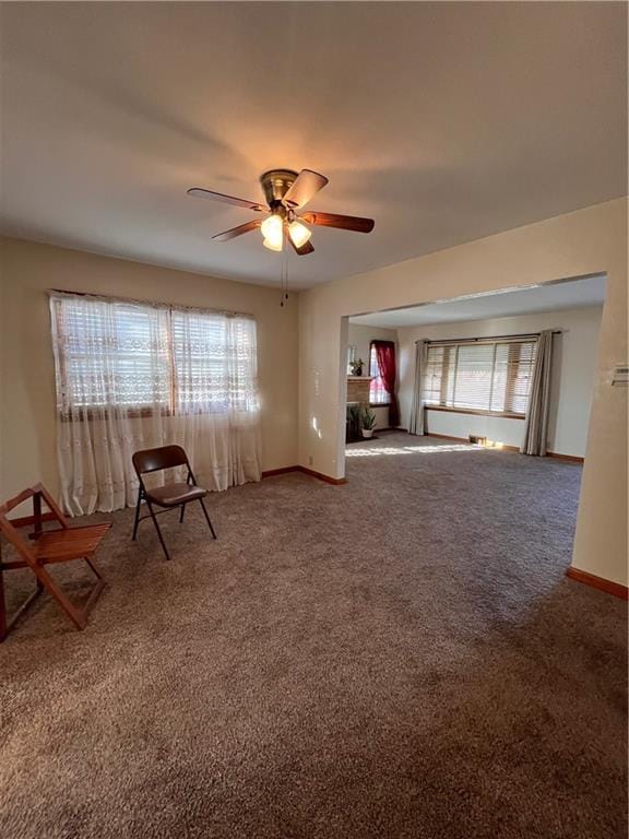 unfurnished room with carpet flooring, a healthy amount of sunlight, baseboards, and ceiling fan