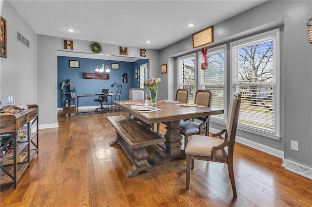 dining area with visible vents, baseboards, and wood finished floors