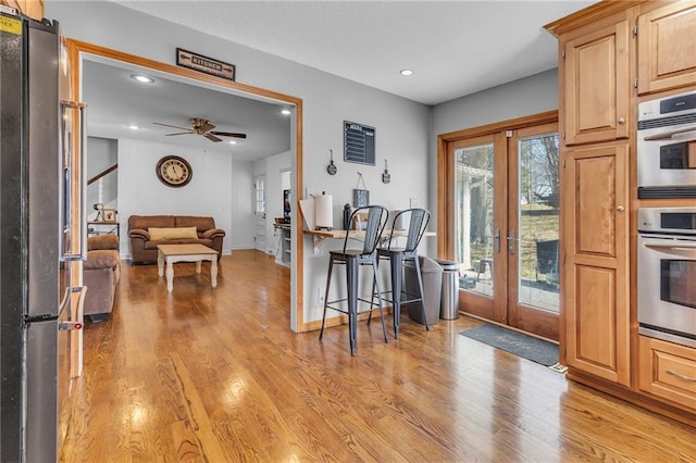 kitchen with light wood finished floors, ceiling fan, recessed lighting, appliances with stainless steel finishes, and french doors