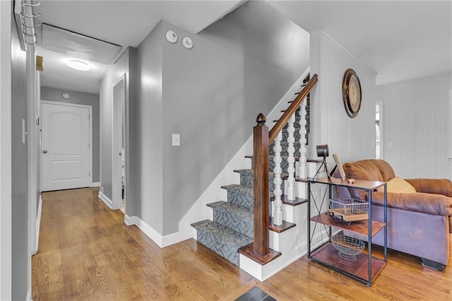 staircase featuring baseboards and wood finished floors