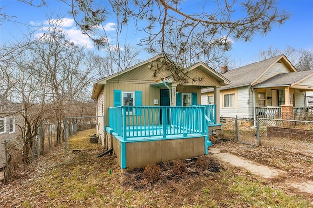 view of front facade with covered porch, board and batten siding, and a fenced backyard