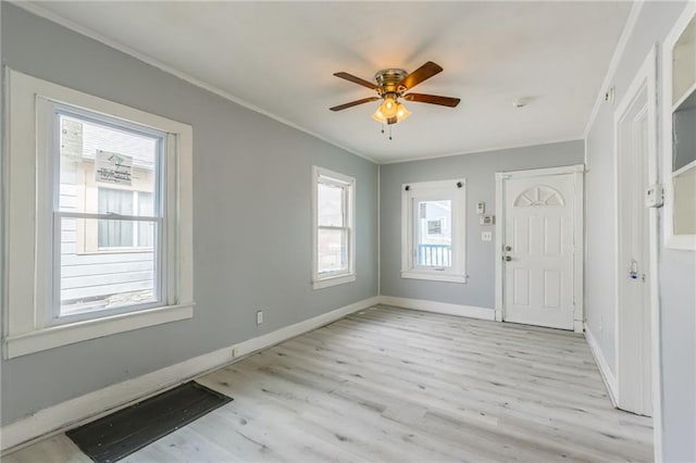 entrance foyer with visible vents, baseboards, ornamental molding, light wood-style floors, and a ceiling fan