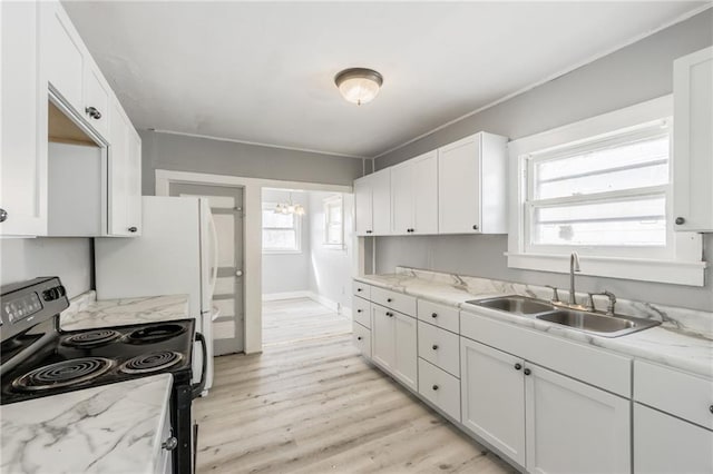 kitchen featuring light wood finished floors, black range with electric cooktop, light stone counters, white cabinets, and a sink