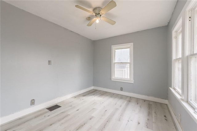 spare room featuring visible vents, baseboards, light wood-style flooring, and a ceiling fan