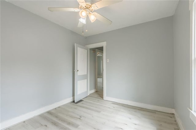 empty room featuring ceiling fan, baseboards, and light wood-style flooring