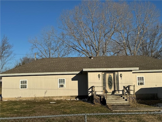 manufactured / mobile home featuring a fenced front yard, a front yard, and roof with shingles