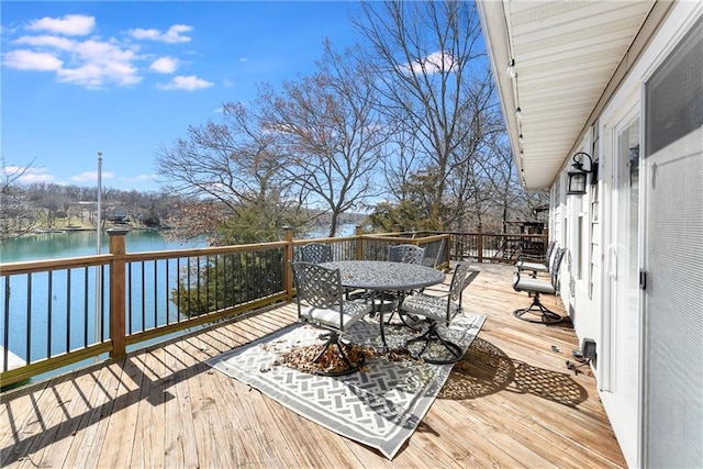 wooden terrace featuring outdoor dining area and a water view