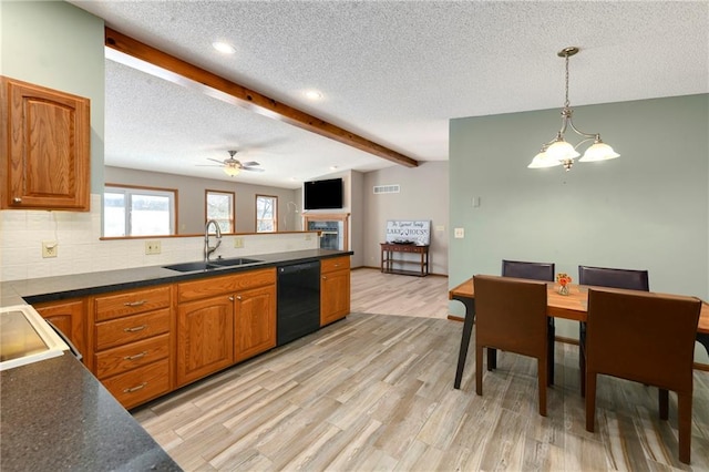 kitchen with lofted ceiling with beams, black dishwasher, light wood-style flooring, a peninsula, and a sink