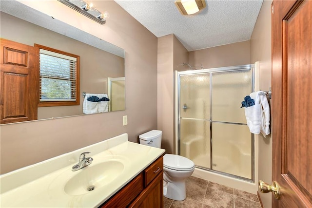 full bathroom with a shower stall, a textured ceiling, toilet, and vanity