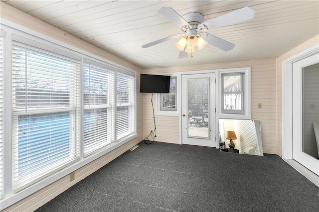 unfurnished sunroom featuring ceiling fan