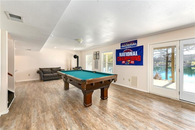 game room featuring visible vents, a textured ceiling, baseboards, and wood finished floors