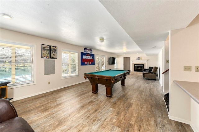 recreation room featuring billiards, a textured ceiling, wood finished floors, and a fireplace