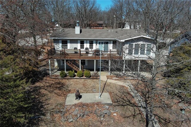 rear view of property with stairs, a chimney, and a wooden deck