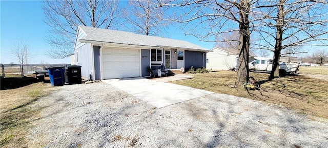 ranch-style home with an attached garage, a shingled roof, driveway, and fence