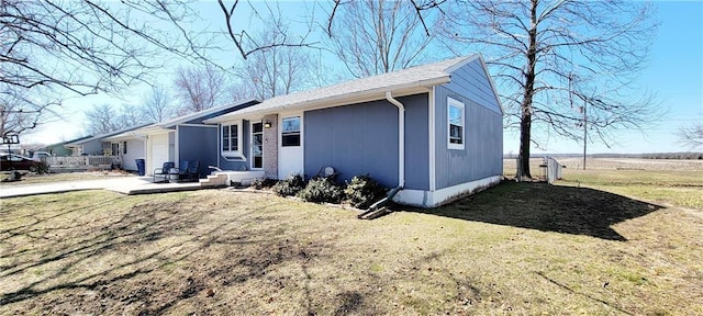 view of front of home with a front yard, a garage, and driveway