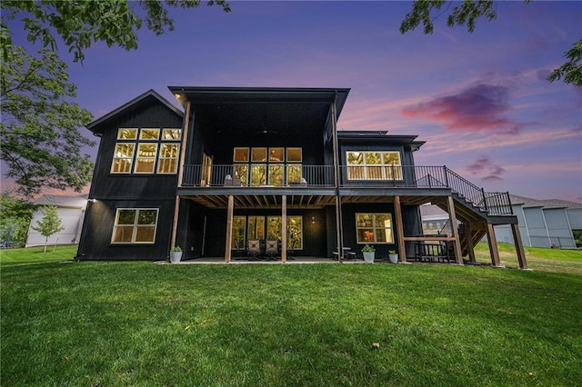 21143 W 189th Ct, Spring Hill, KS 66083 - back of house at dusk with stairs, a yard, a deck, and a patio