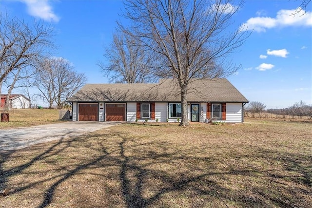 view of front facade featuring a garage, a front yard, and dirt driveway