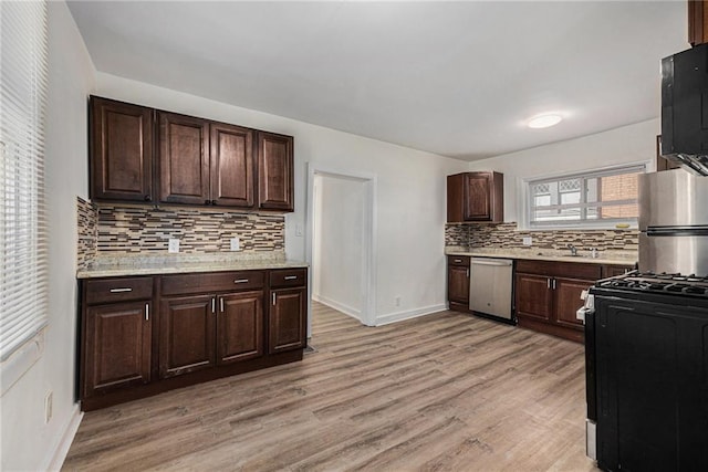 kitchen with gas stove, dishwasher, light wood-style flooring, and black microwave