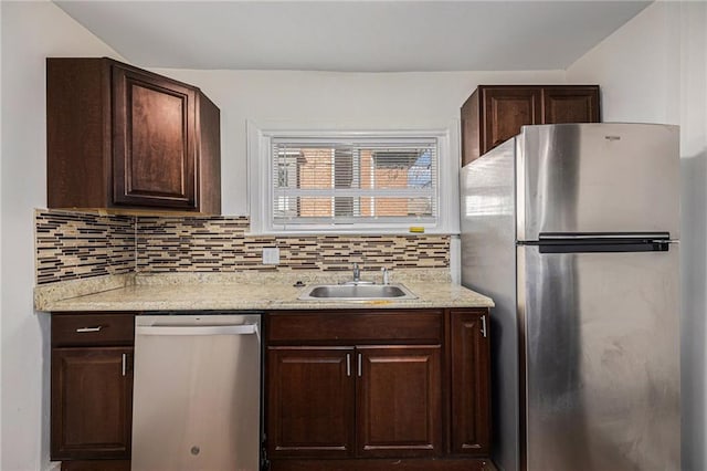 kitchen with a sink, stainless steel appliances, backsplash, and dark brown cabinets