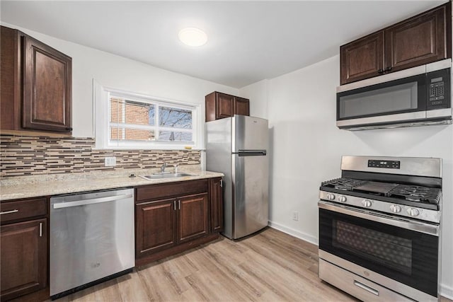 kitchen with a sink, dark brown cabinetry, and appliances with stainless steel finishes