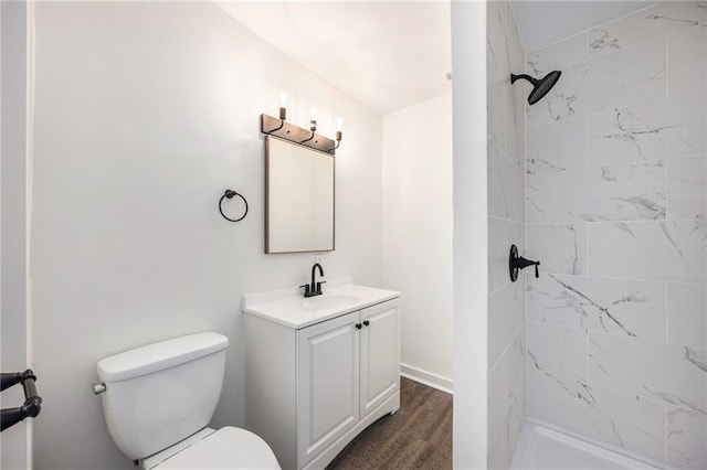 bathroom with wood finished floors, toilet, a stall shower, and vanity