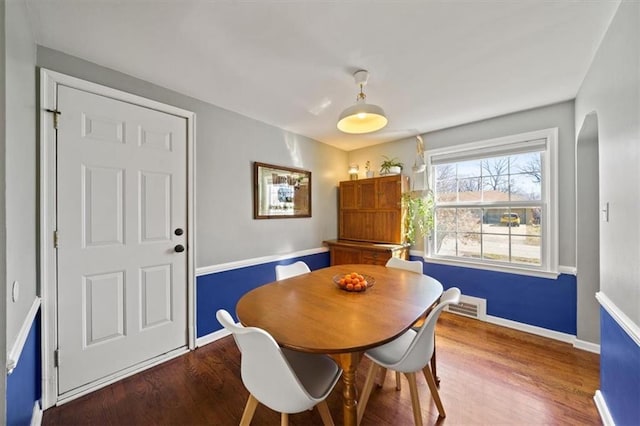 dining space with visible vents, baseboards, and wood finished floors