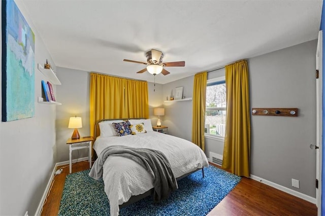 bedroom with ceiling fan, baseboards, and wood finished floors