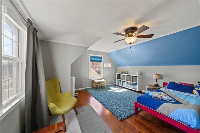 bedroom with ceiling fan, baseboards, wood finished floors, and vaulted ceiling