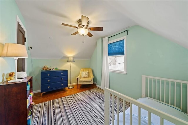 bedroom with a ceiling fan, lofted ceiling, wood finished floors, and baseboards