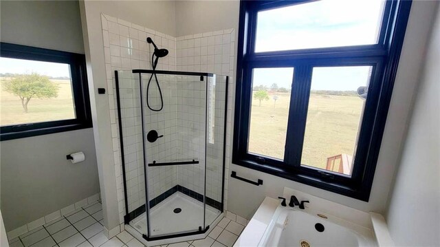 bathroom with a jetted tub, a shower stall, and a healthy amount of sunlight