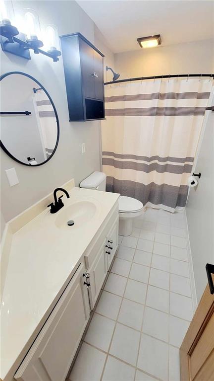 bathroom with tile patterned flooring, toilet, vanity, and a shower with curtain