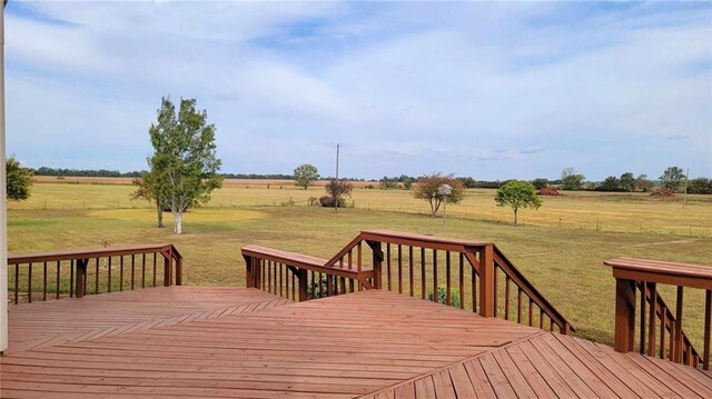 wooden deck featuring a rural view and a lawn