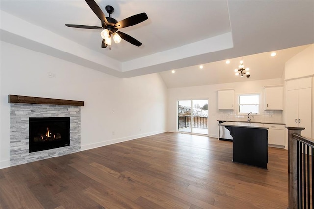 unfurnished living room with dark wood-type flooring, a sink, recessed lighting, a fireplace, and baseboards