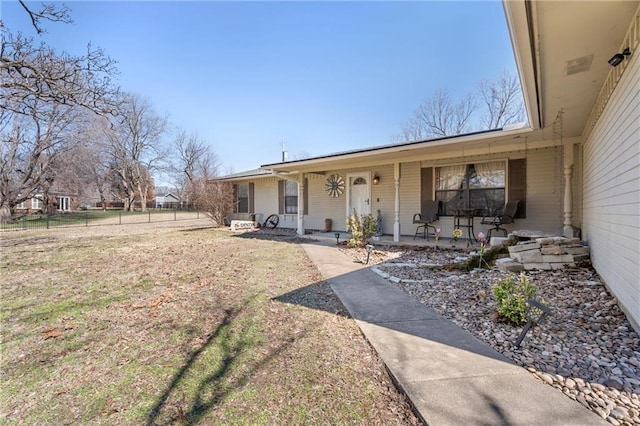 exterior space featuring covered porch and fence
