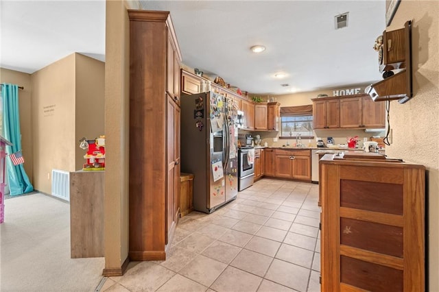 kitchen with a sink, brown cabinetry, visible vents, and stainless steel appliances