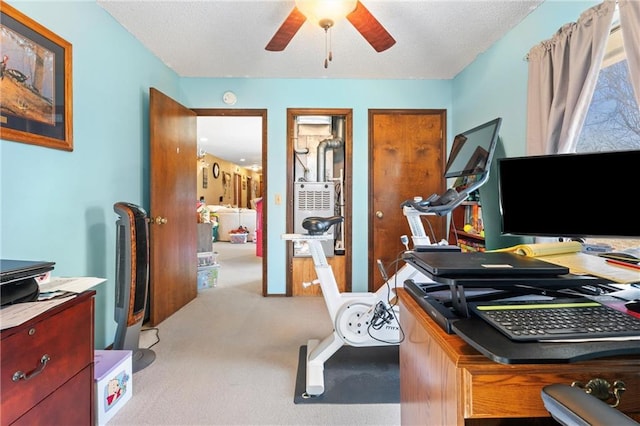 office featuring light carpet, a textured ceiling, and ceiling fan