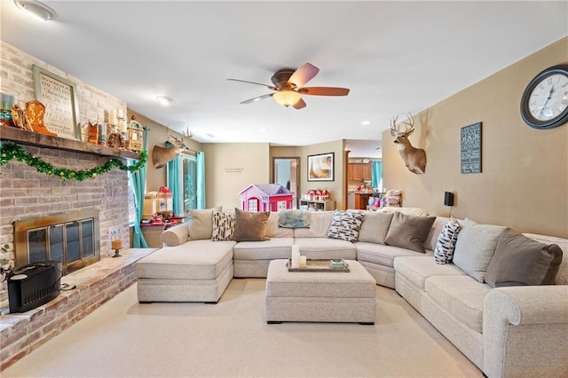 carpeted living area featuring a brick fireplace and a ceiling fan