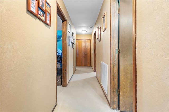 hallway with visible vents and a textured wall