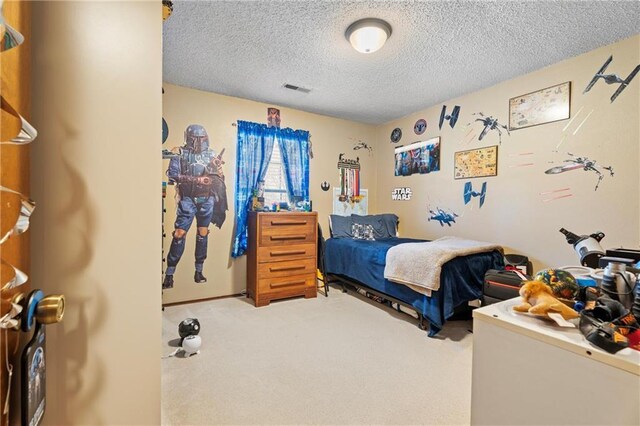 carpeted bedroom featuring visible vents and a textured ceiling
